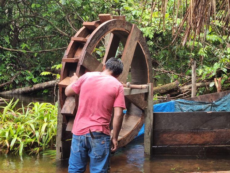 Community member checking experimental water wheel.